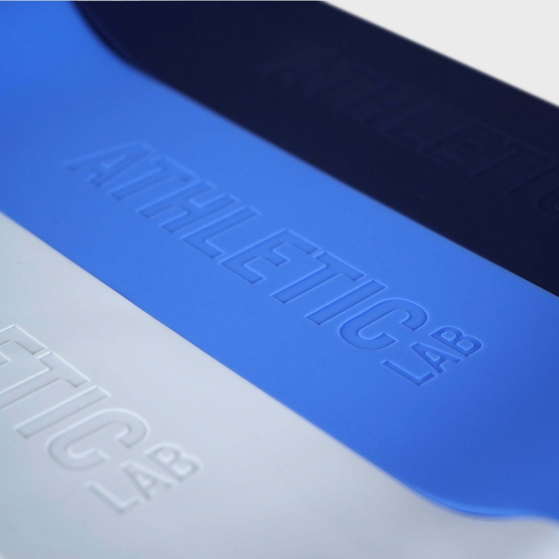 Close-up of a blue and grey resistance loop bands with "Athletic Lab" branding.