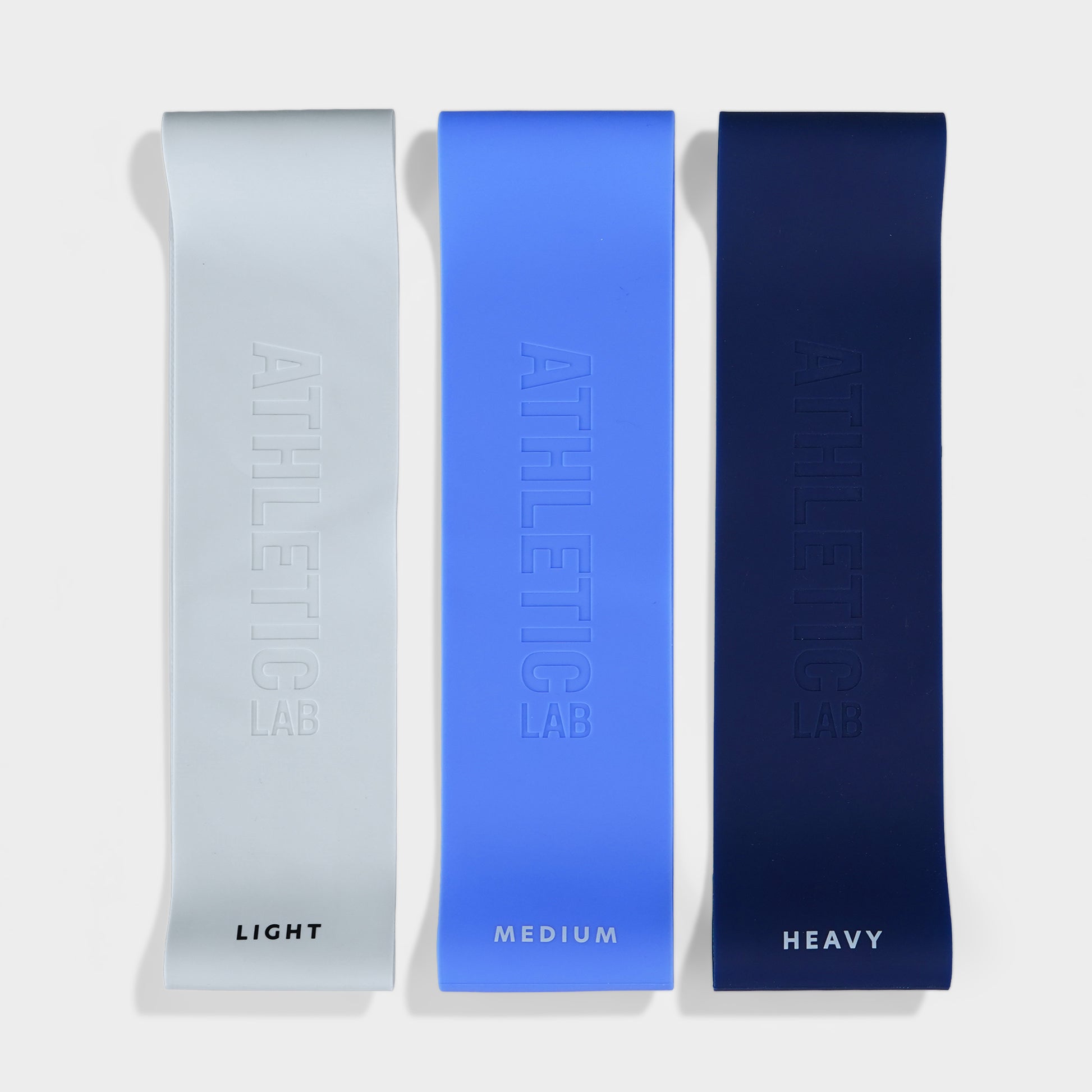 Three resistance bands labeled 'Light', 'Medium', and 'Heavy' on a white background.